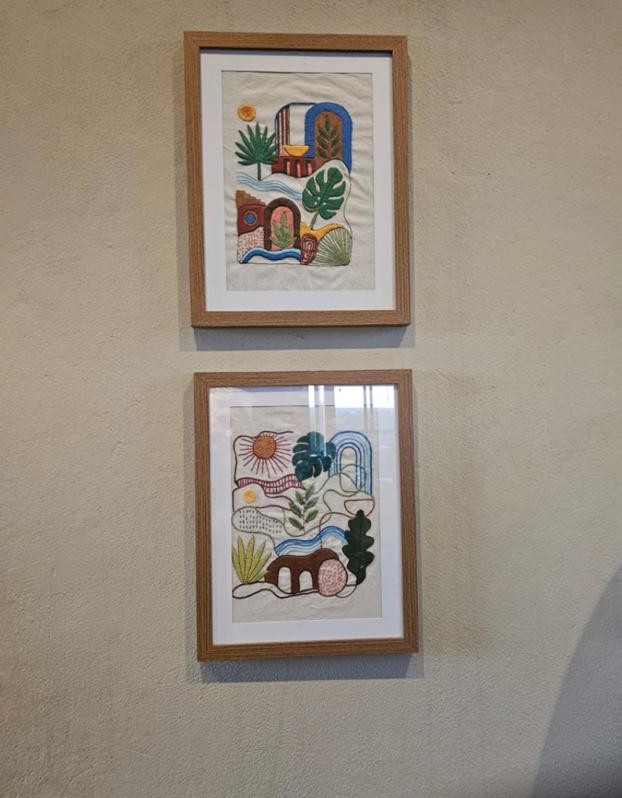 Dois quadros bordados pela aluna Eliana, emoldurados na parede